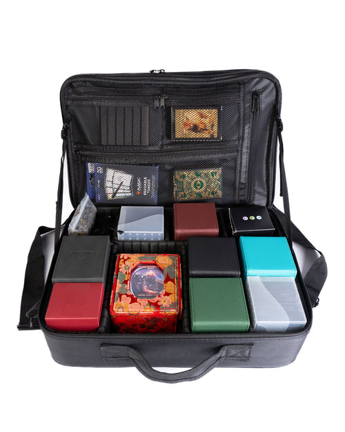 Black carrying case with compartments holding various small boxes and items on a white background